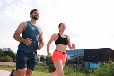 Photo of Healthy lifestyle. Happy couple running outdoors, space for text