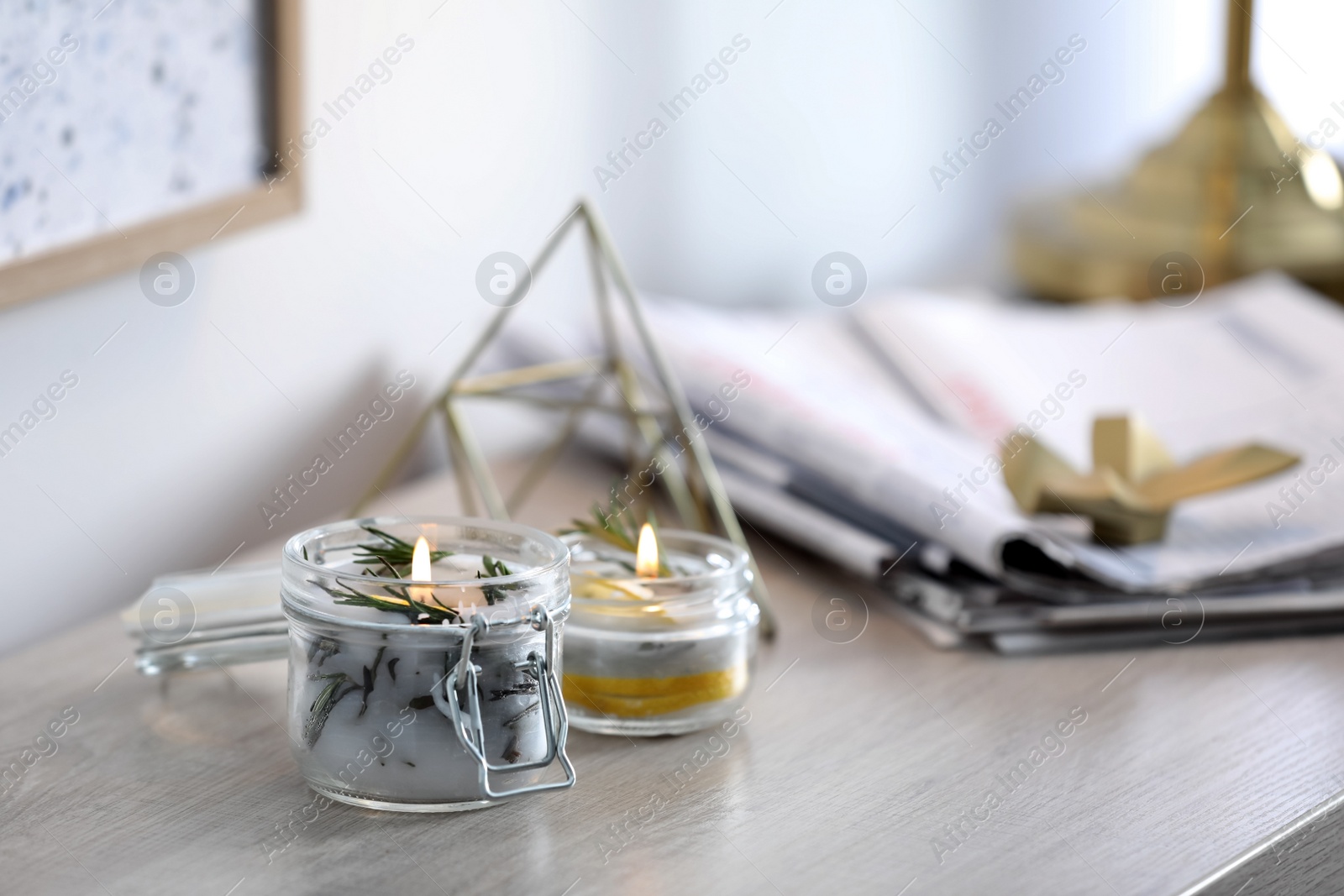 Photo of Natural homemade mosquito repellent candles on wooden table in room. Space for text