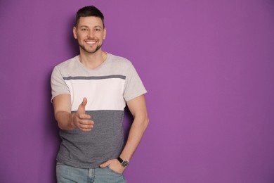 Man offering handshake on purple background, space for text