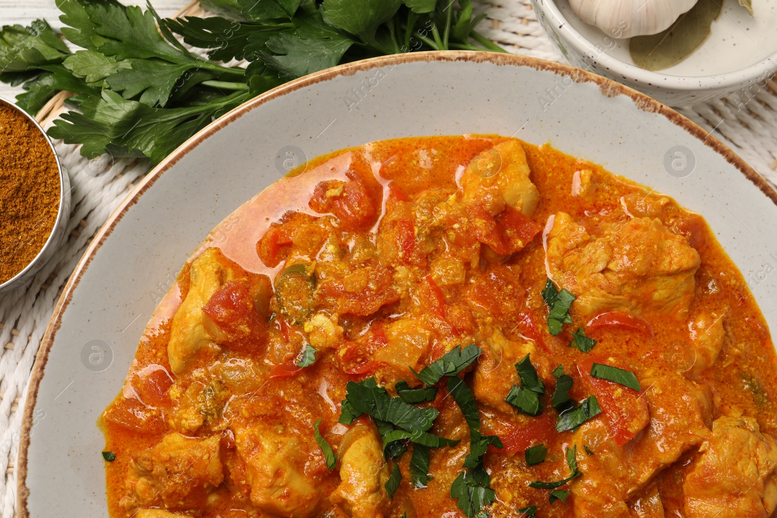 Photo of Delicious chicken curry and ingredients on table, top view