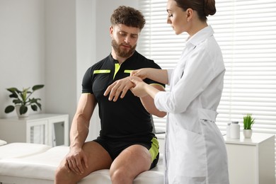 Photo of Doctor in uniform examining injured sportsman in hospital