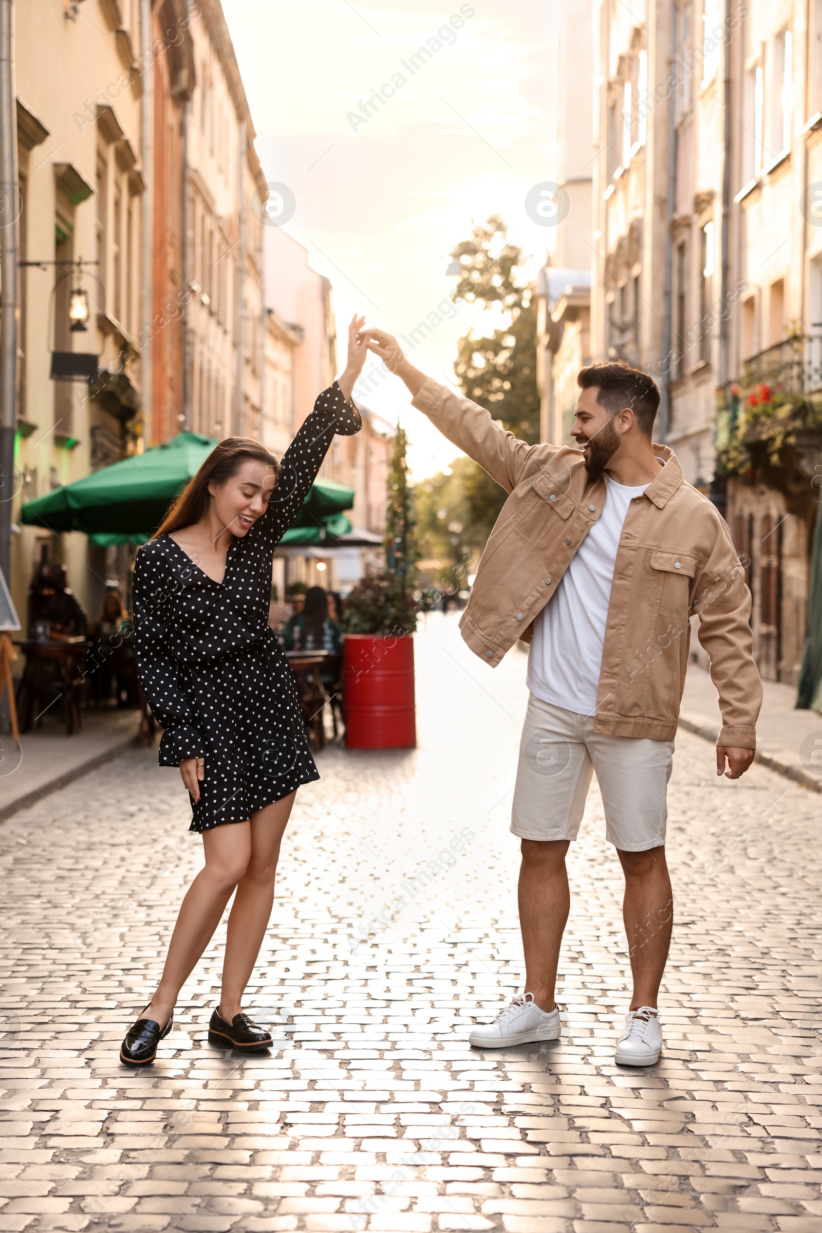 Photo of Lovely couple dancing together on city street