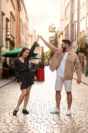 Lovely couple dancing together on city street