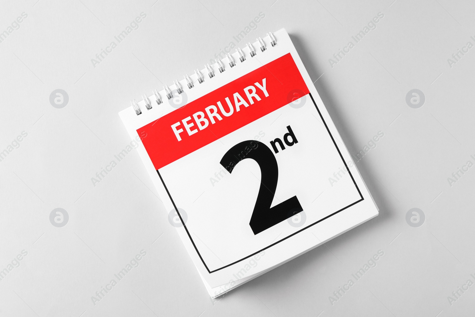 Photo of Top view of calendar with date February 2nd on light background. Groundhog day