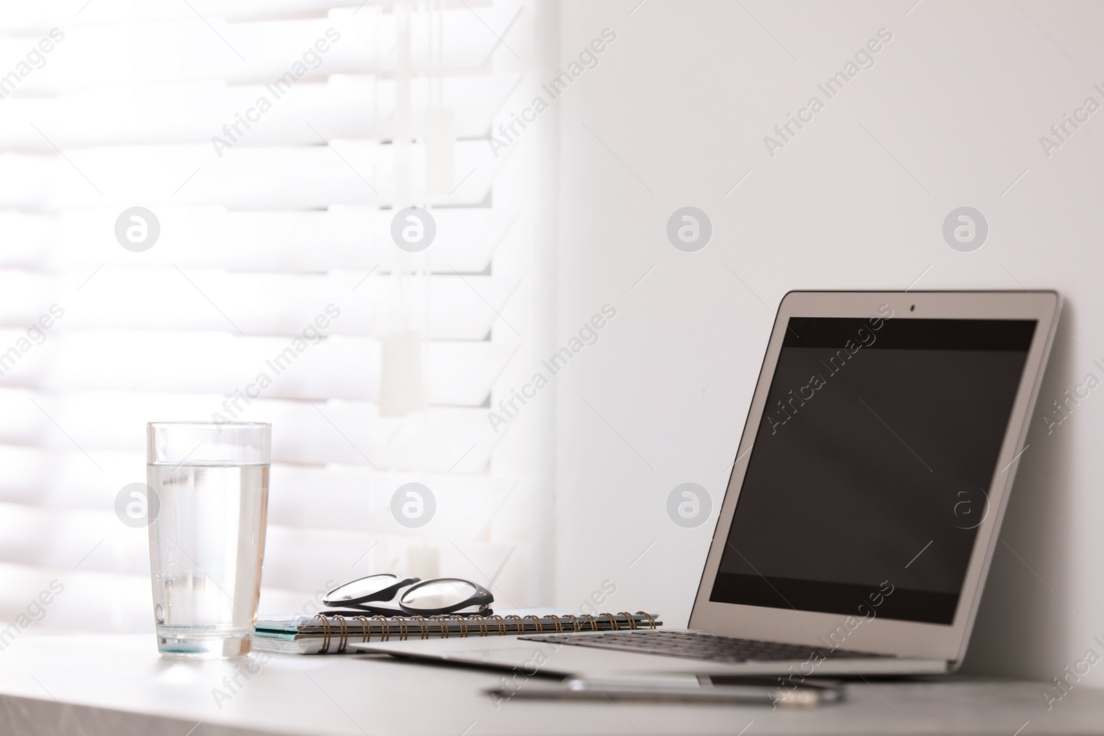 Photo of Modern workplace with laptop on grey table in office