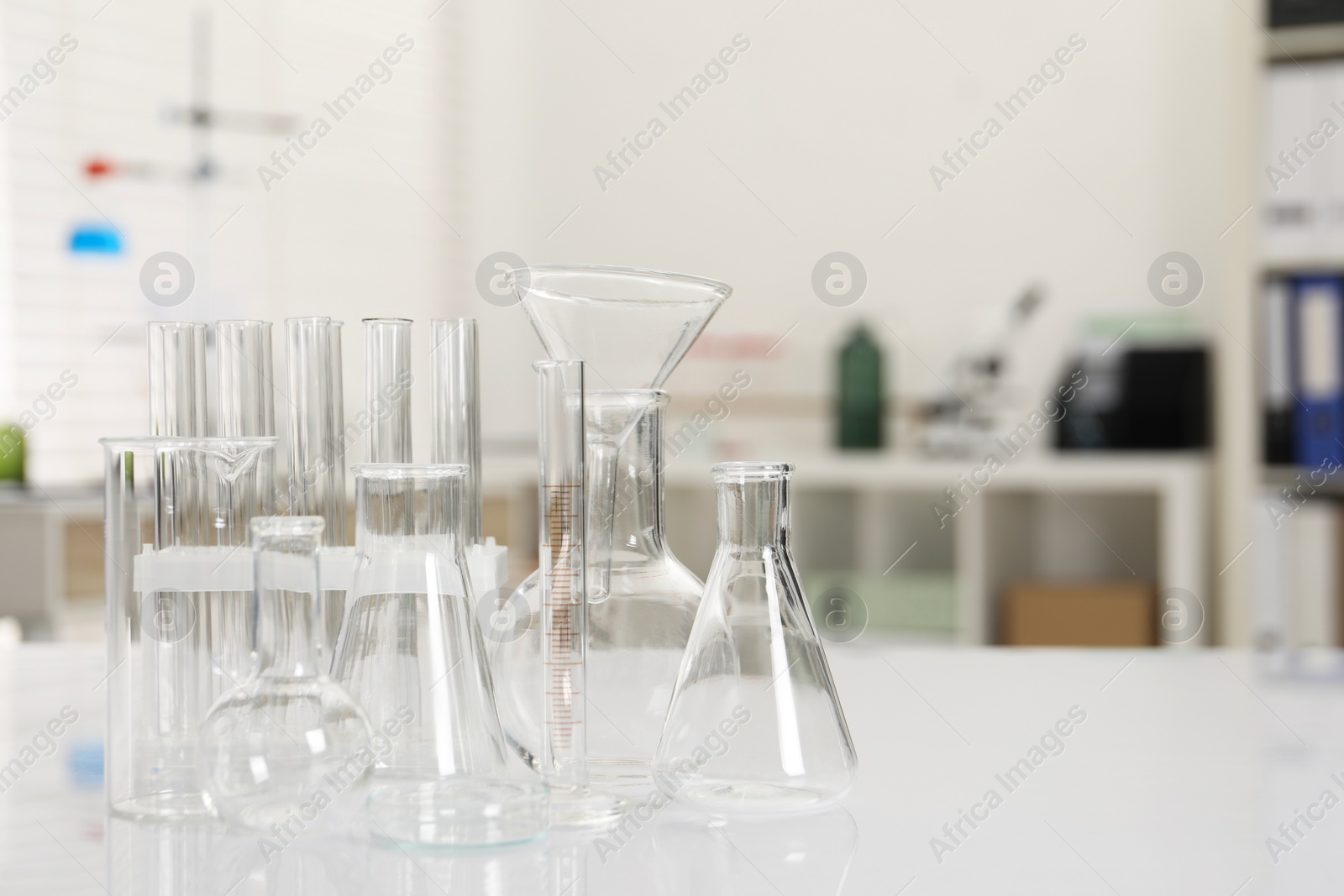 Photo of Laboratory analysis. Different glassware on white table indoors, space for text