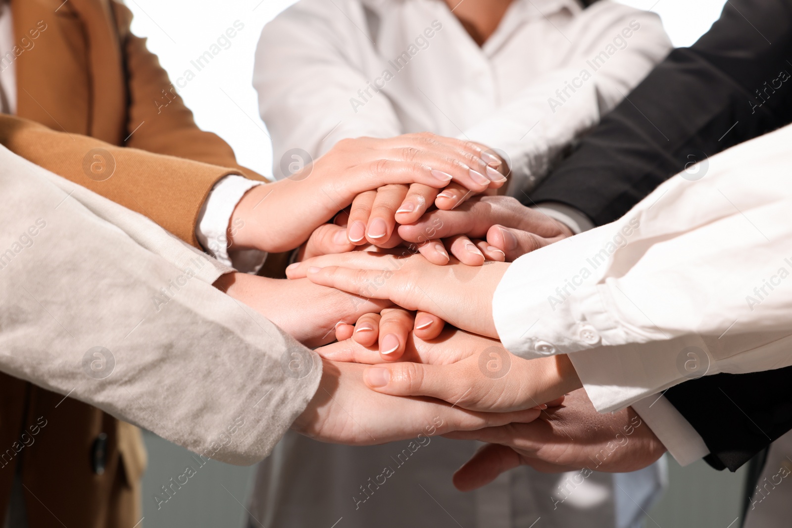 Photo of Group of people holding hands together, closeup. Unity concept