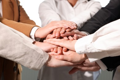 Photo of Group of people holding hands together, closeup. Unity concept