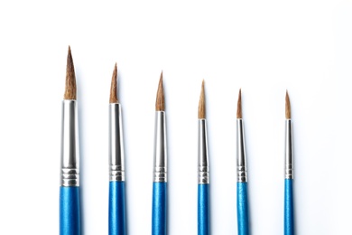 Photo of Different paint brushes on white background, top view