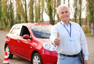 Photo of Senior instructor near modern car outdoors. Get driving license