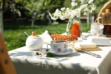 Beautiful table setting in spring garden on sunny day