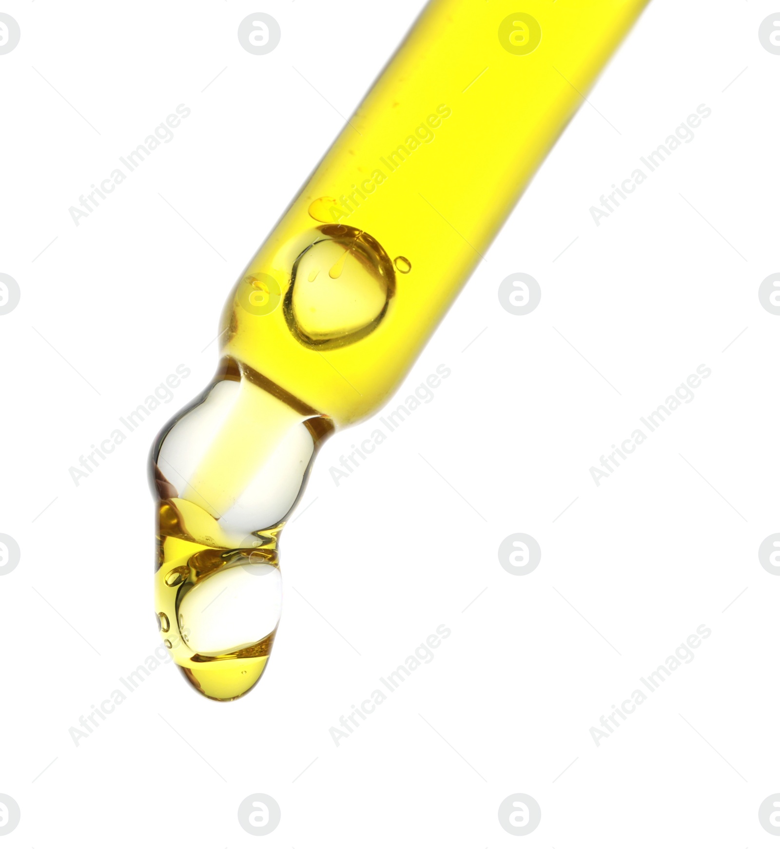 Photo of Dripping yellow facial serum from pipette on white background, closeup