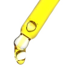 Photo of Dripping yellow facial serum from pipette on white background, closeup