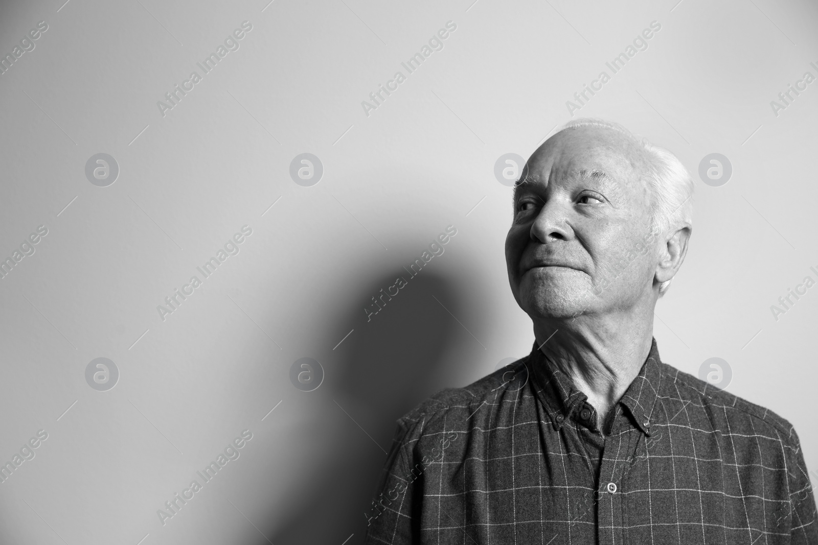 Photo of Portrait of elderly man on light background, space for text. Black and white effect