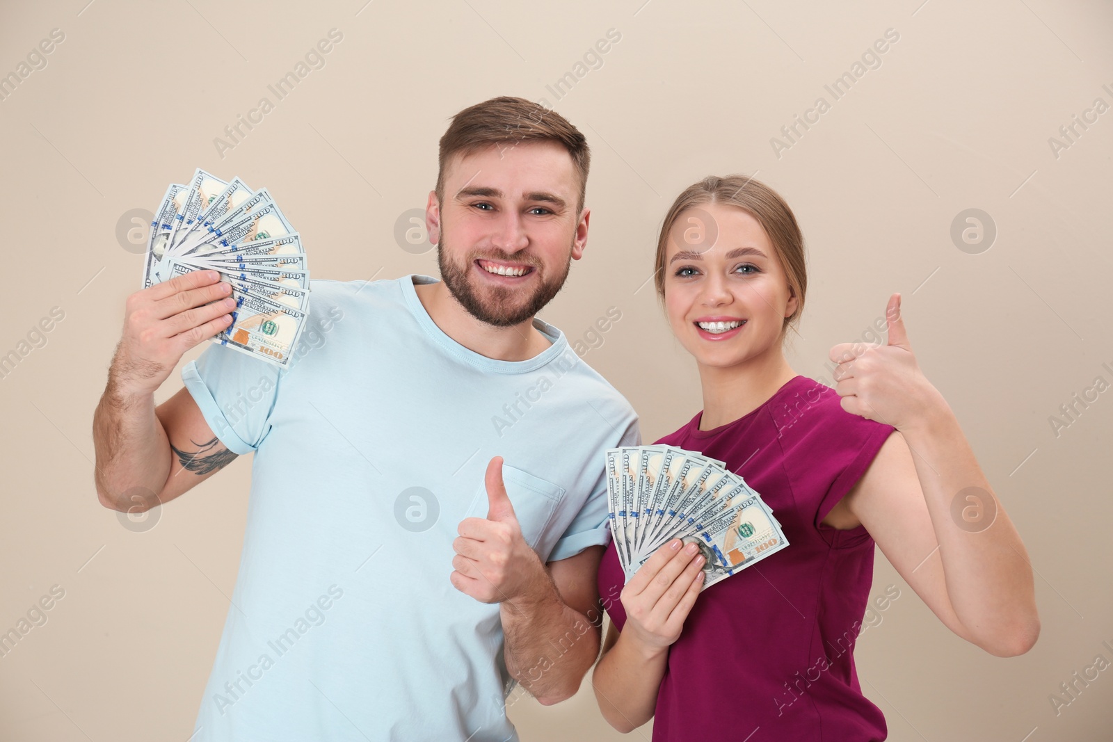 Photo of Happy young couple with money on color background