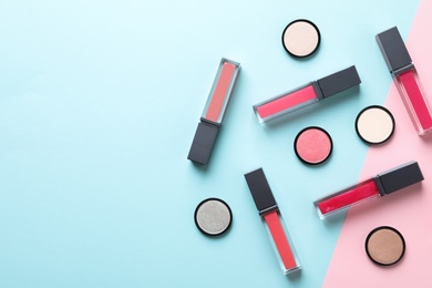 Photo of Composition of lipsticks and eyeshadows on color background, flat lay. Space for text