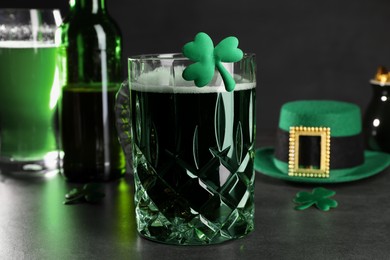 St. Patrick's day celebration. Green beer, leprechaun hat and decorative clover leaves on grey table