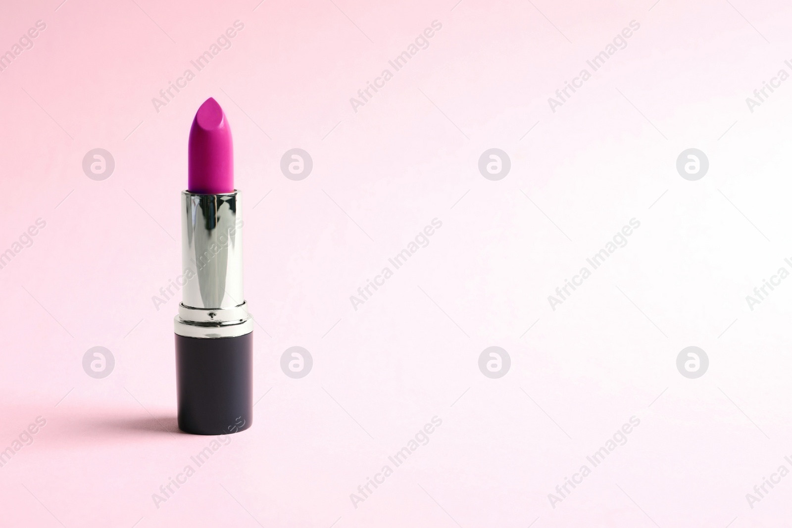 Image of Pink lipstick on color background. Space for text