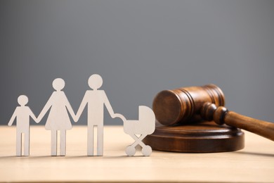 Family law. Figure of parents with children and gavel on wooden table