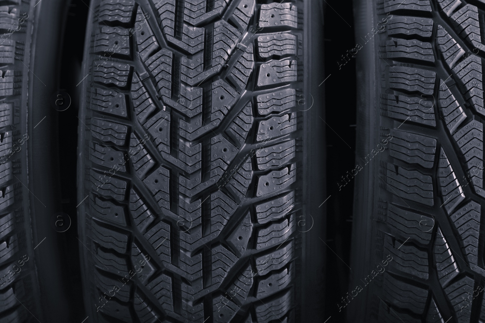 Photo of Black car tires as background, closeup. Auto store