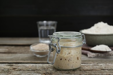 Photo of Leaven, flour and water on wooden table