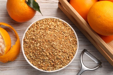 Photo of Bowl with dried orange seasoning zest and fruits on white wooden table, flat lay