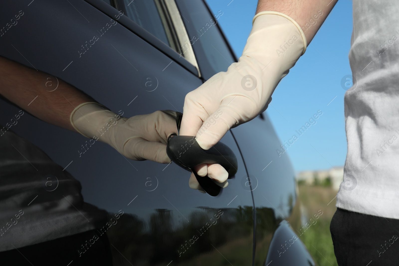 Photo of Man in gloves opening car door, closeup view