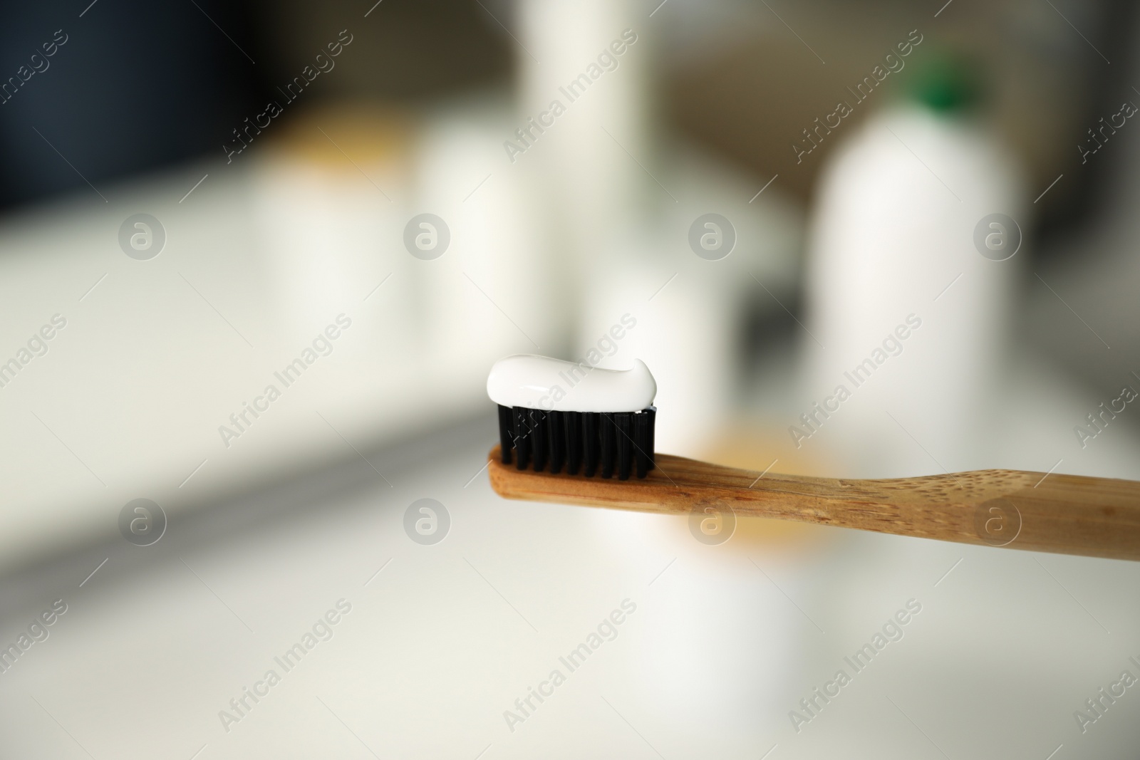 Photo of Toothbrush with paste on blurred background, closeup