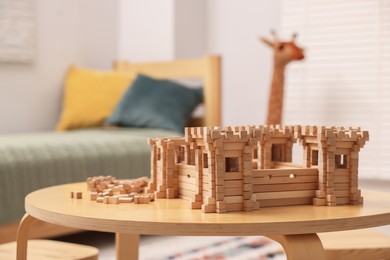 Wooden fortress and building blocks on table indoors, space for text. Children's toy