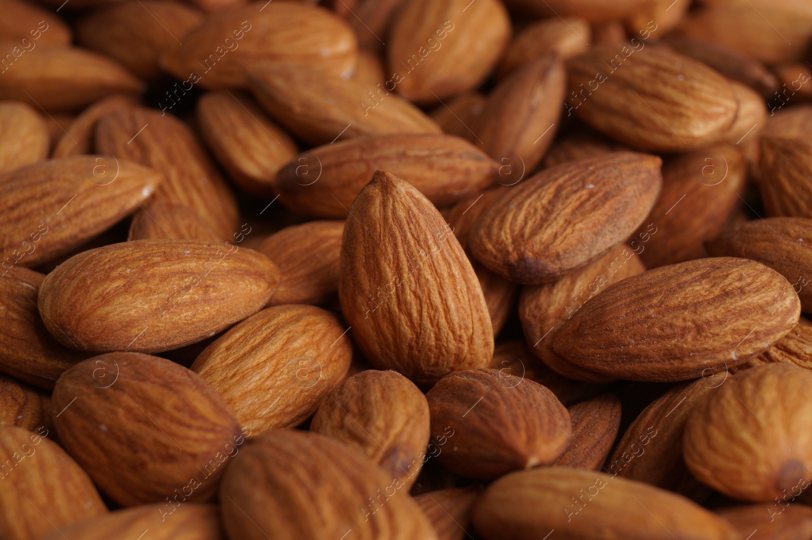 Photo of Pile of delicious raw ripe almonds, closeup