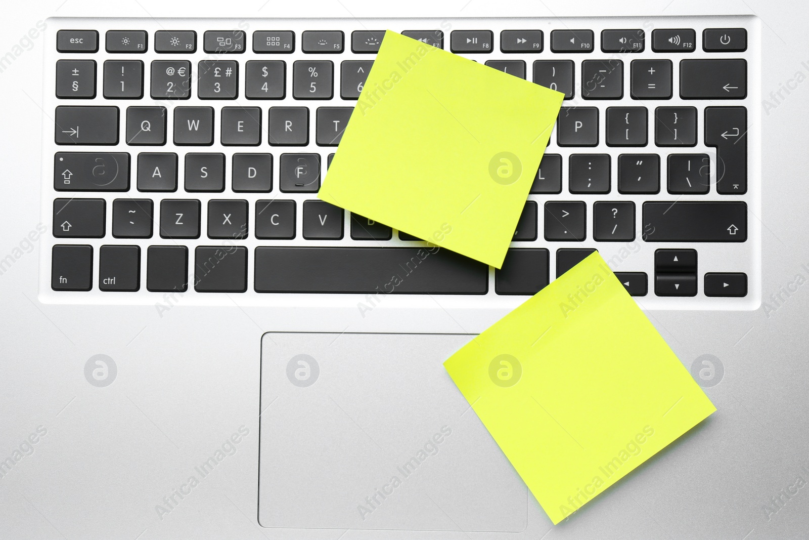 Photo of Empty sticky notes on laptop, top view. Space for design