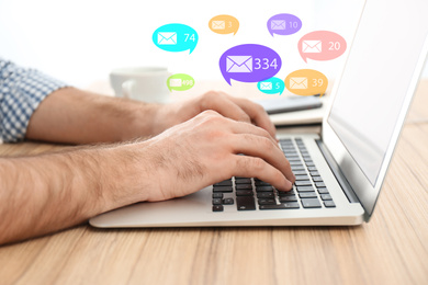 Image of Man using laptop at wooden table indoors, closeup. Social media