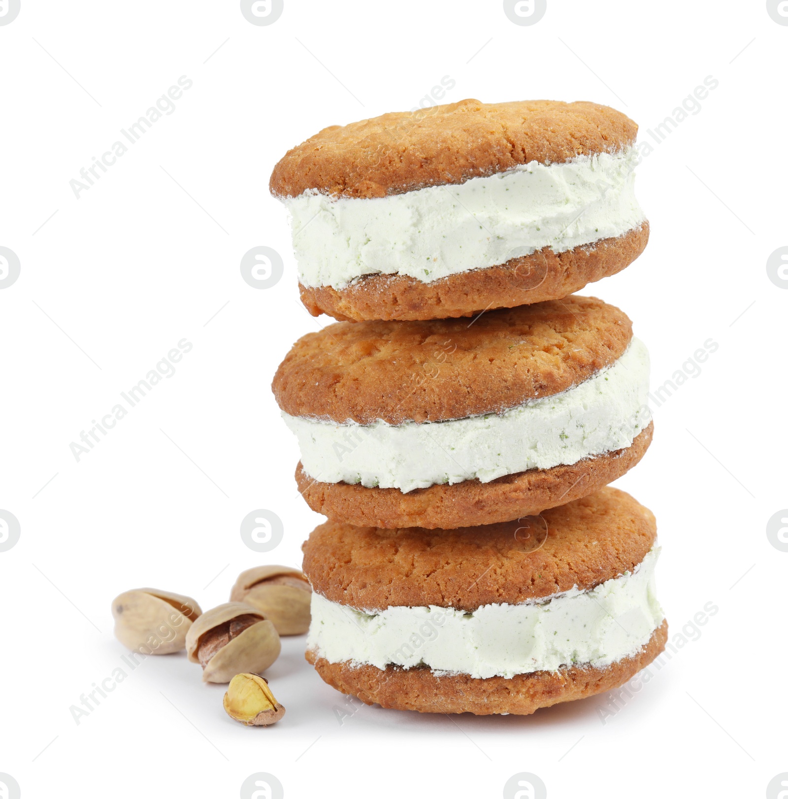 Photo of Sweet delicious ice cream cookie sandwiches and pistachios on white background