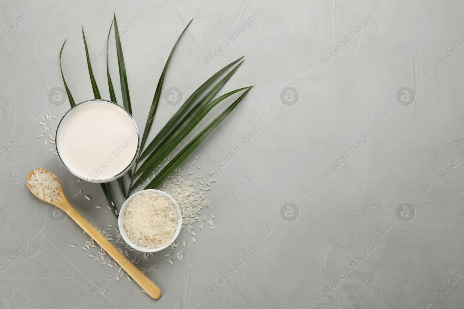 Photo of Delicious rice milk and grains on light grey table, flat lay. Space for text