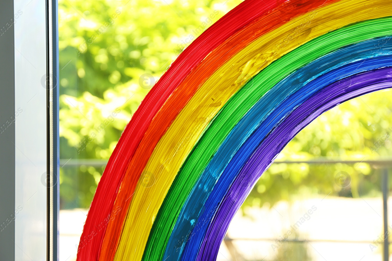 Photo of Picture of rainbow on window glass indoors, closeup. Stay at home concept