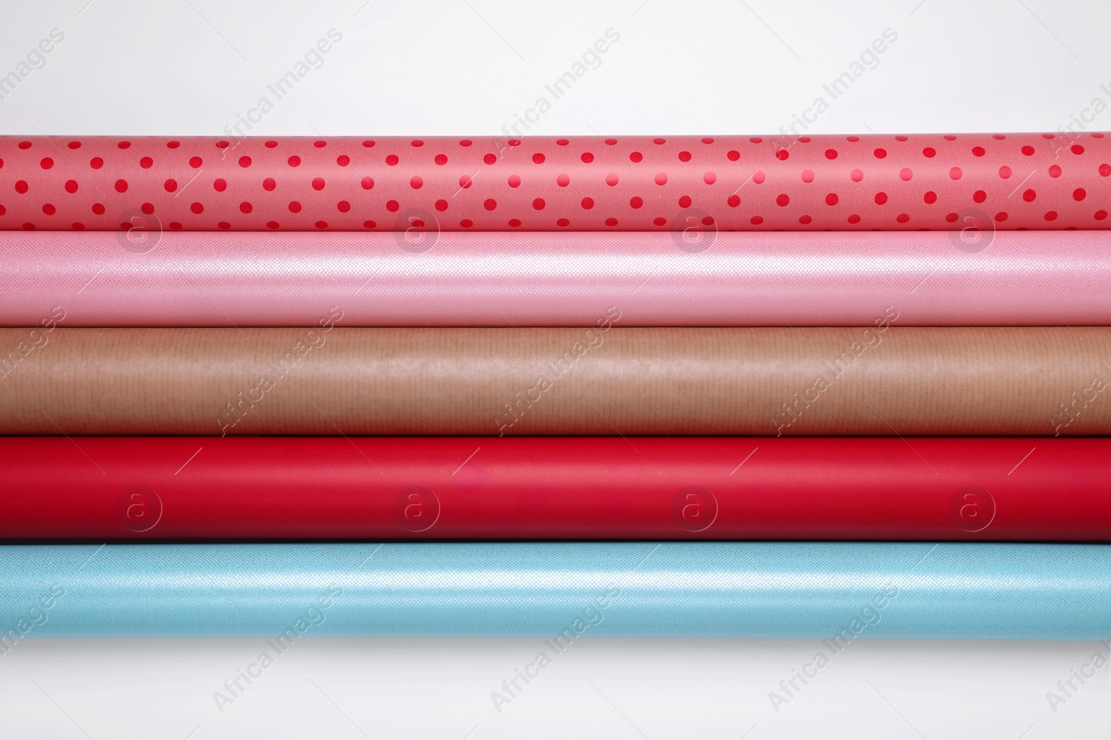 Photo of Rolls of different bright wrapping paper on white background, top view