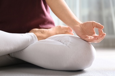 Photo of Woman practicing yoga on floor indoors, closeup