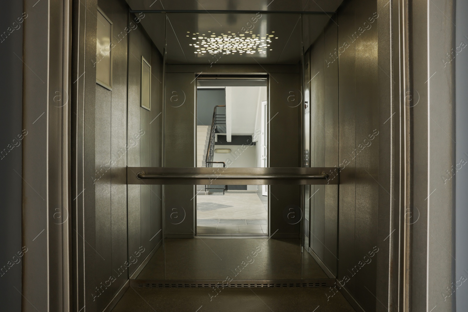 Photo of Open elevator`s cabin with big mirror indoors