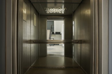 Open elevator`s cabin with big mirror indoors