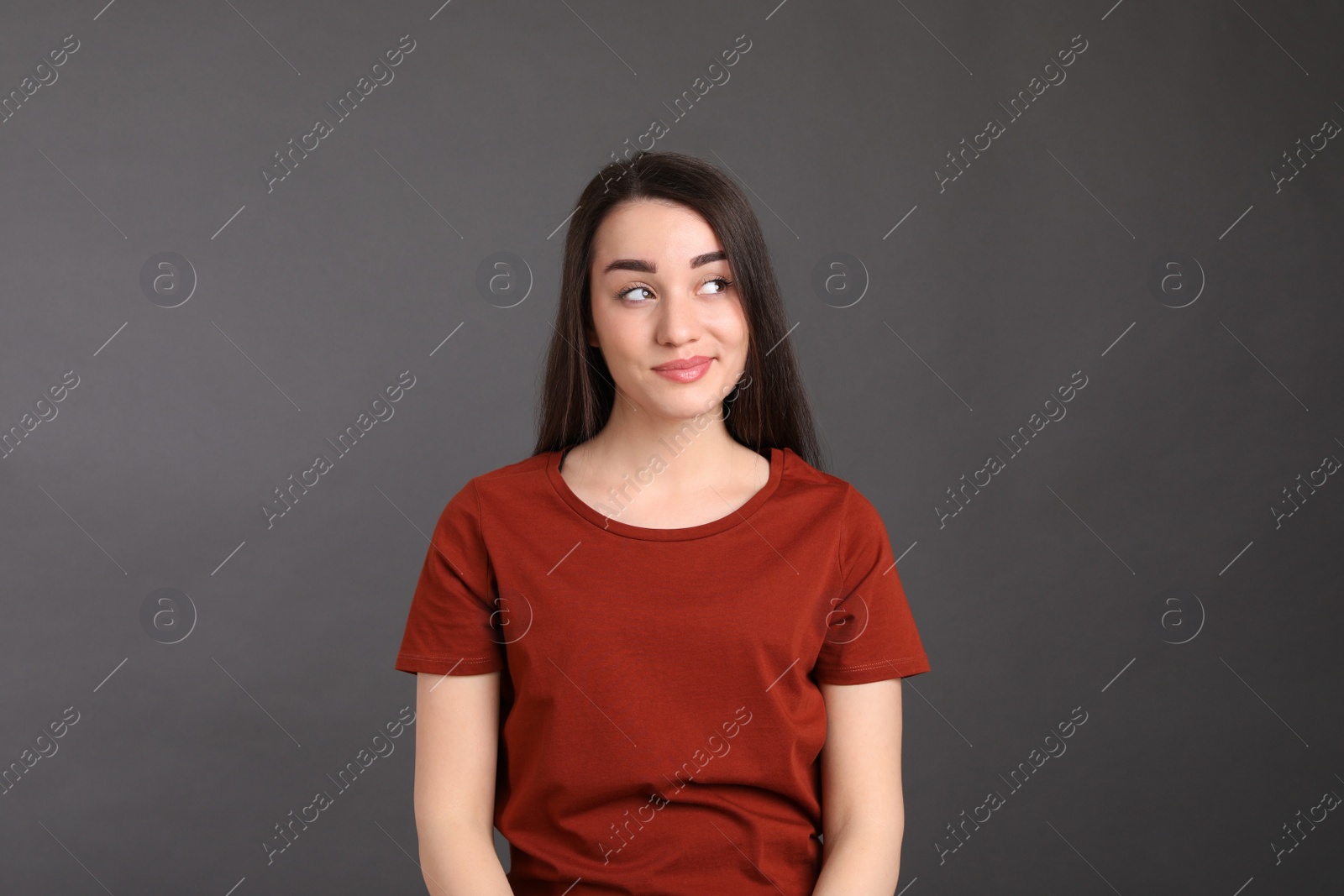 Photo of Portrait of happy young woman on dark grey background. Personality concept