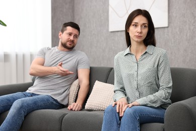 Offended wife ignoring her husband indoors. Relationship problems