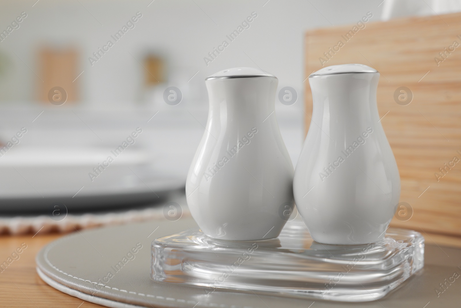 Photo of White ceramic salt and pepper shakers on wooden table, space for text