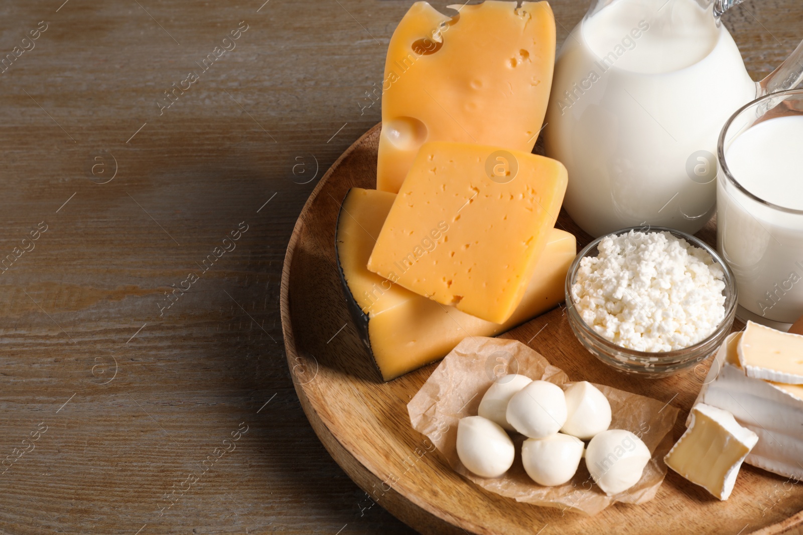 Photo of Different delicious dairy products on wooden table