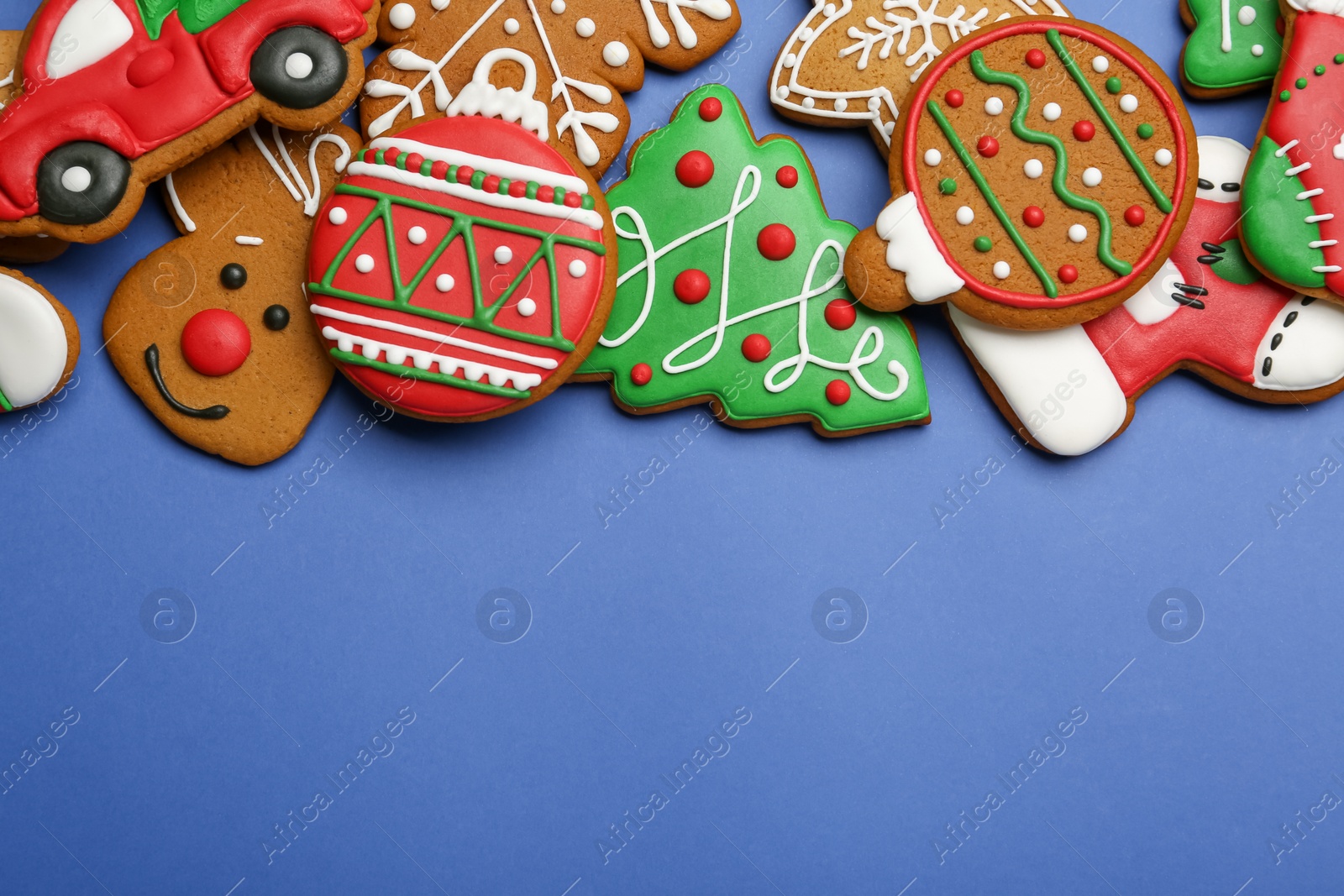 Photo of Different tasty Christmas cookies on blue background, flat lay. Space for text