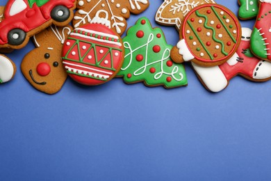Photo of Different tasty Christmas cookies on blue background, flat lay. Space for text