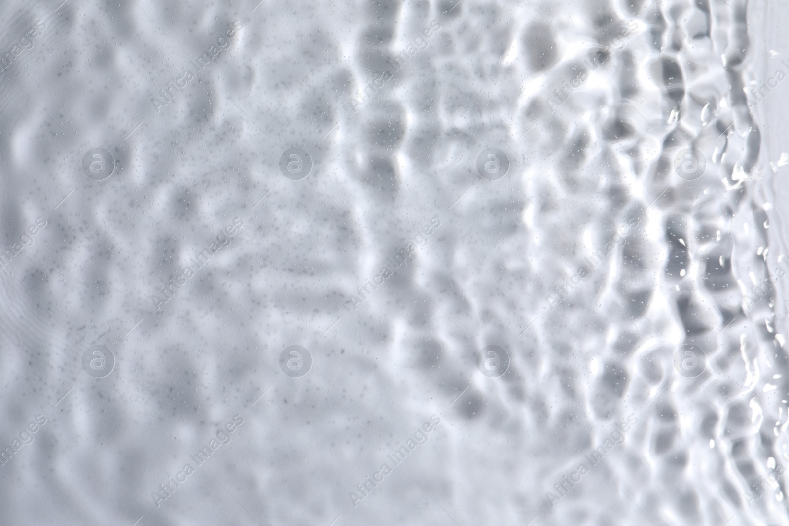 Photo of Closeup view of water with rippled surface on light background