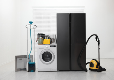 Photo of Refrigerator and different household appliances in room