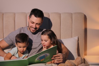 Father reading bedtime story to his children at home