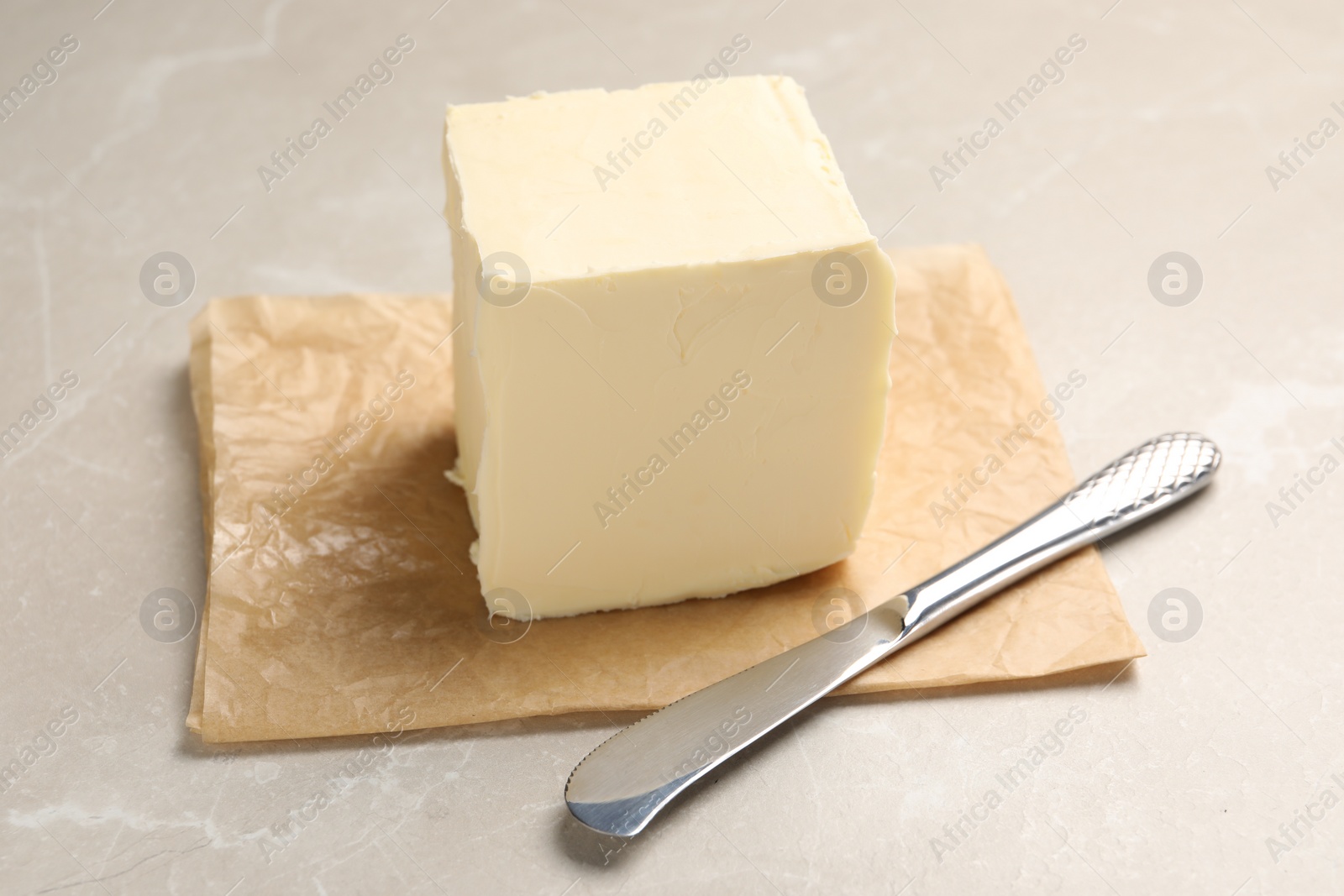 Photo of Block of tasty butter and knife on light table