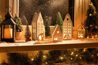 House shaped lanterns and Christmas decor on windowsill indoors